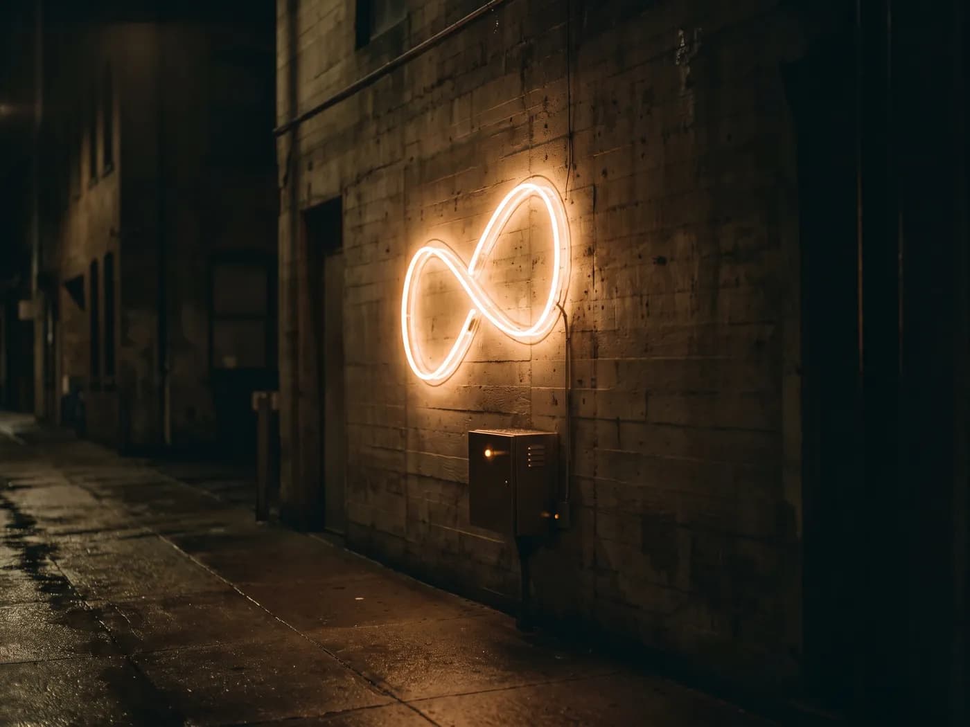 The finished neon sign lit on a concrete wall at night, seen from a wet street